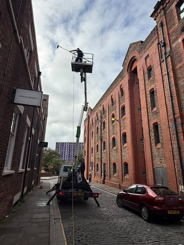 Cherry picker positioned on a Liverpool street to reach roof glazing